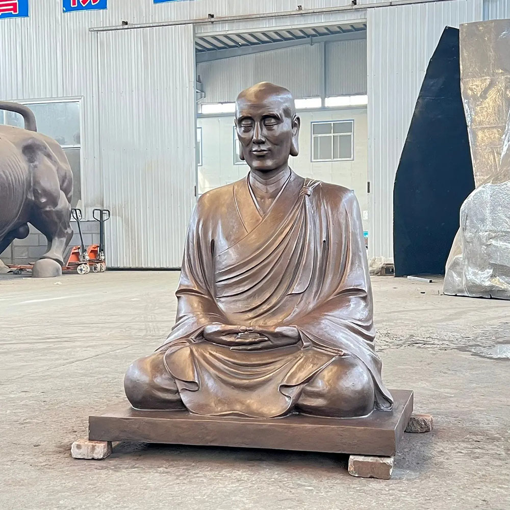 Seated Bronze Monk Statue in workshop setting