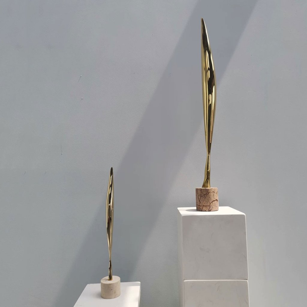 7 Two polished brass abstract bird sculptures displayed