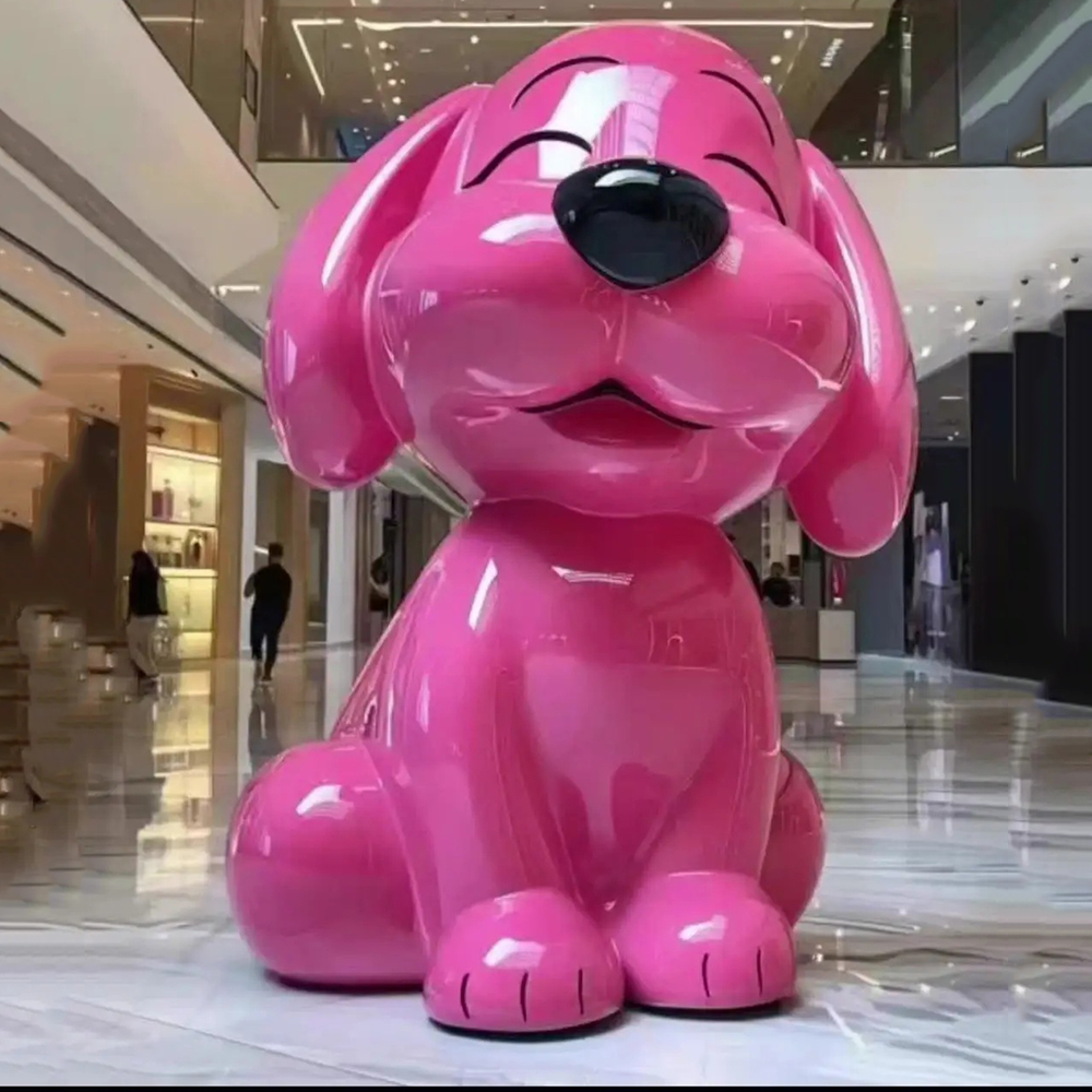 Pink fiberglass cartoon dog sculpture sitting in mall