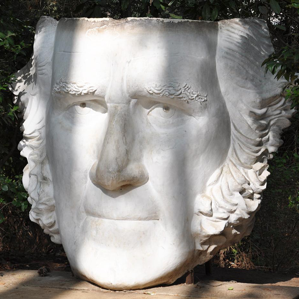 White concrete portrait head with curled sideburns